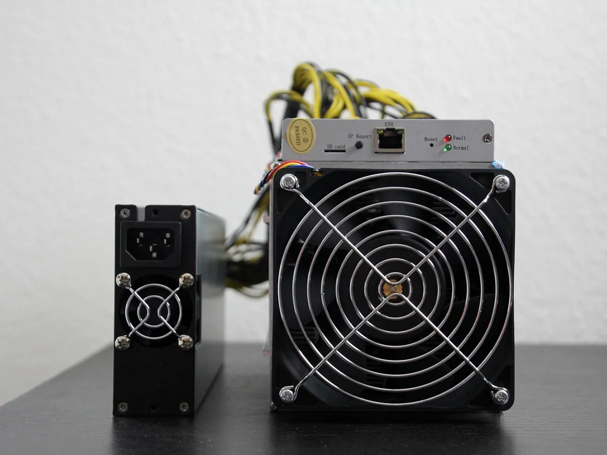 Antminer ASIC mining unit with fans and ethernet port on a shelf