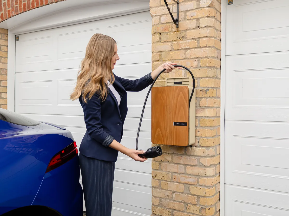 Electric vehicle charging on a wall charger inside a home garage