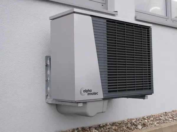 Air-source heat pump outdoor unit mounted on an exterior wall